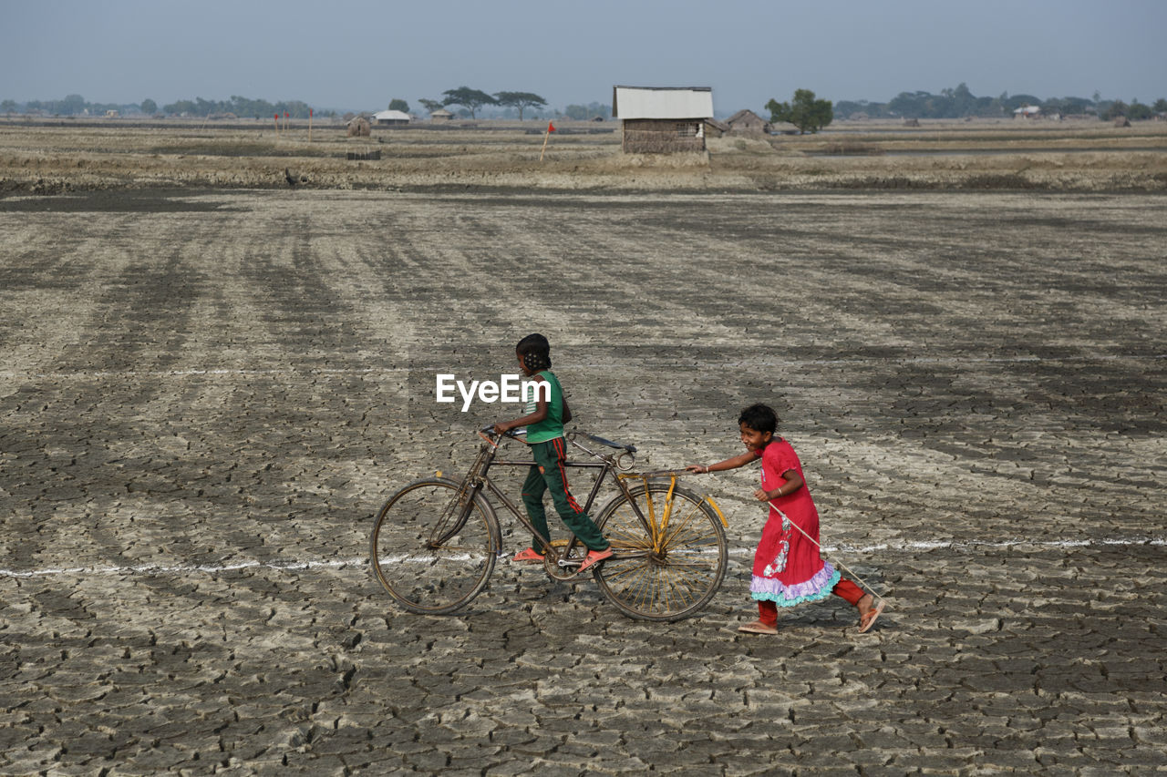 CHILDREN RIDING BICYCLE ON LAND