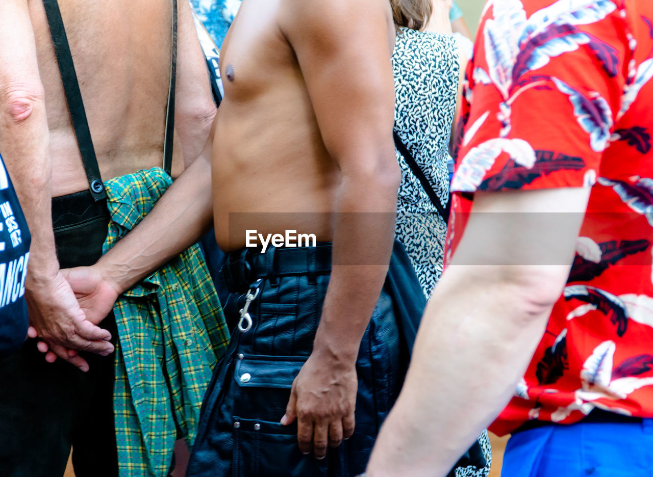 Midsection of gay couple walking in parade