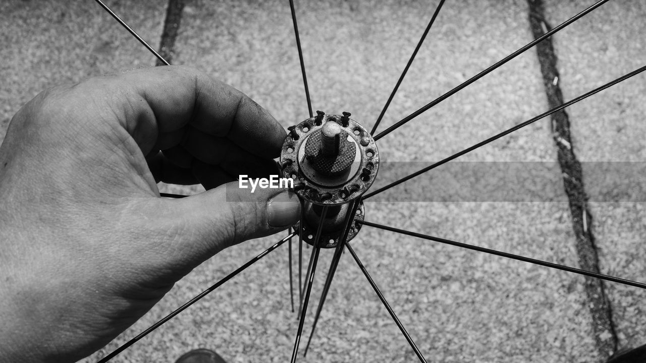 Close-up of male hand touching bicycle wheel hub