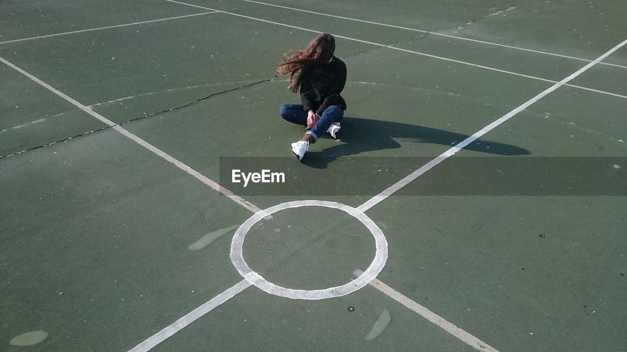 High angle view of woman sitting on playing field