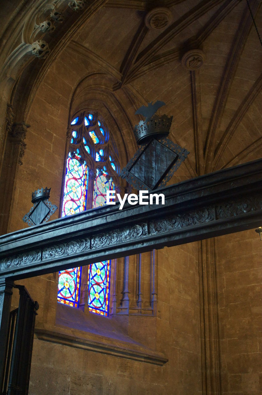 LOW ANGLE VIEW OF CROSS ON WINDOW