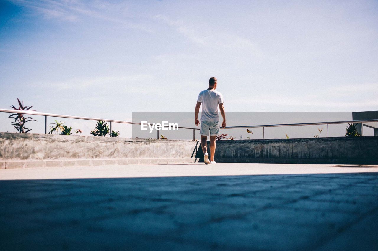 Rear view of man walking on building terrace