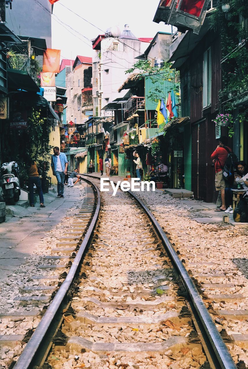 Railroad tracks amidst buildings in city