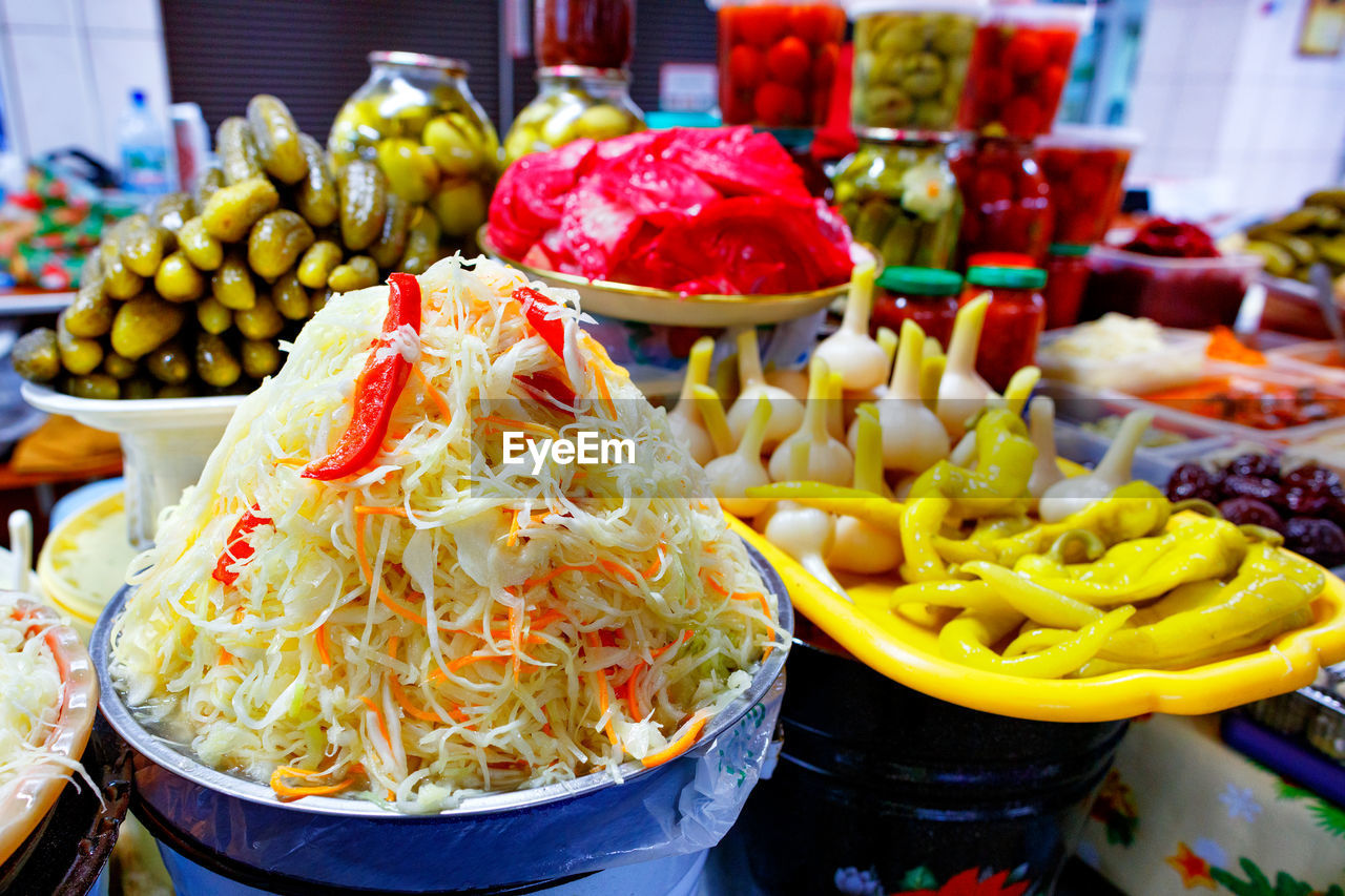 Pickled vegetables, hill salad with sauerkraut, carrots and sweet peppers on the background .