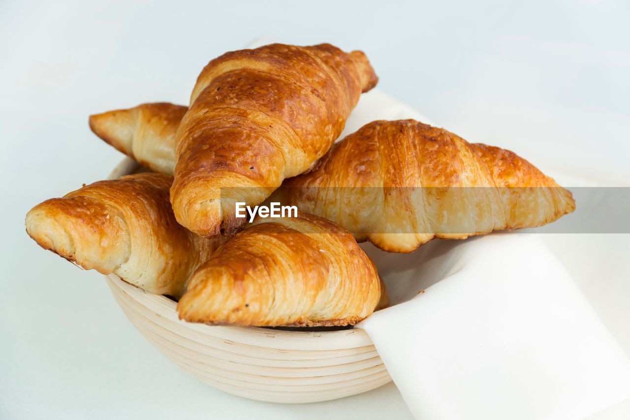 Close-up of croissants in bowl on white background