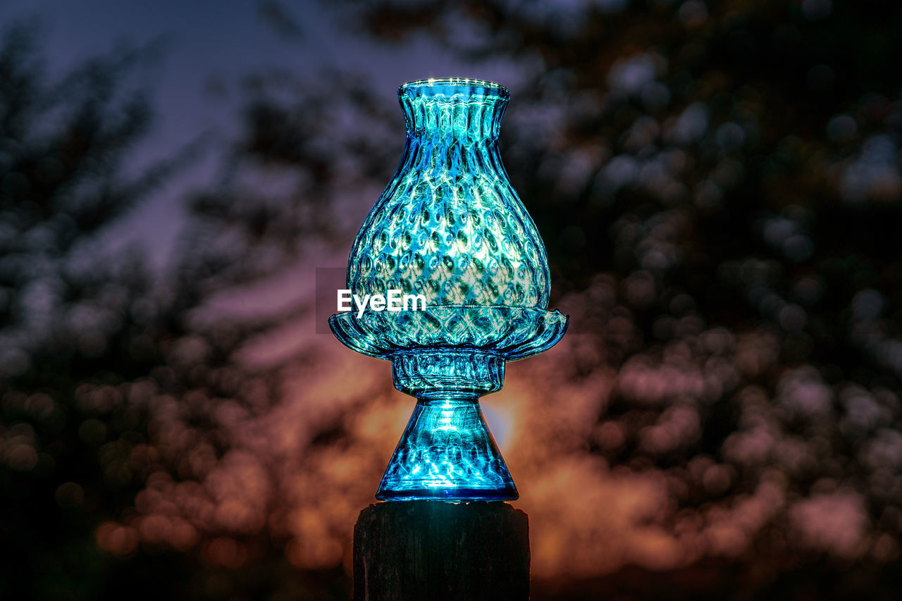 Crystal glass candle holder glowing from the sunset with abstract background and light effect