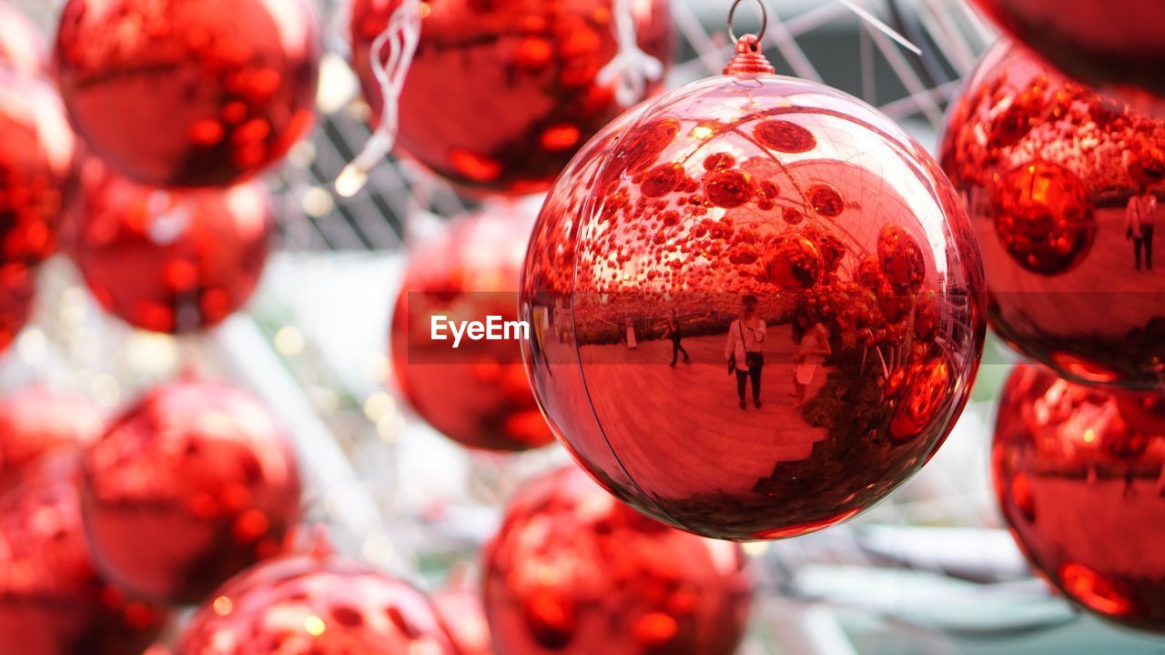 Close-up of red christmas baubles hanging outdoors