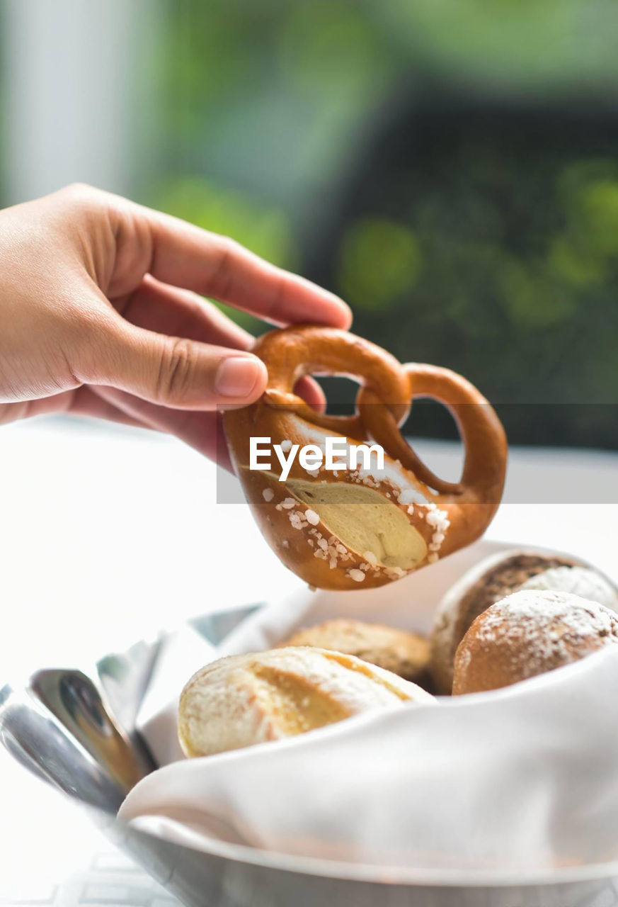 Cropped hand of person holding donuts