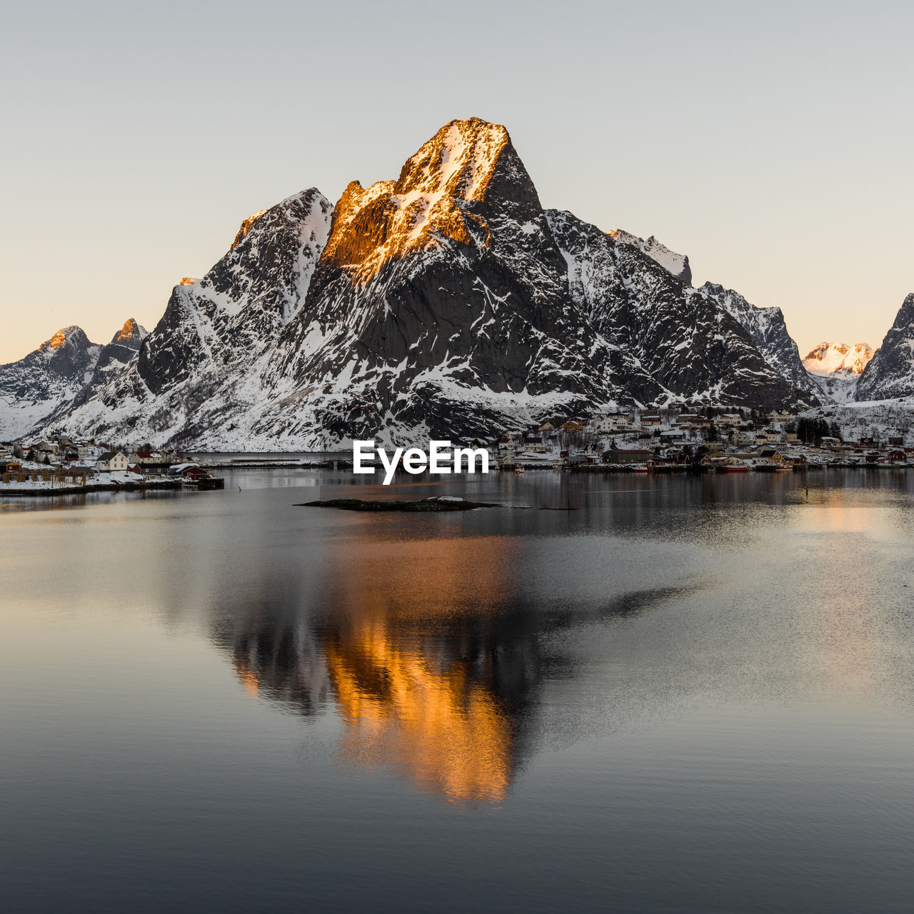 Scenic view of lake and snowcapped mountains against clear sky