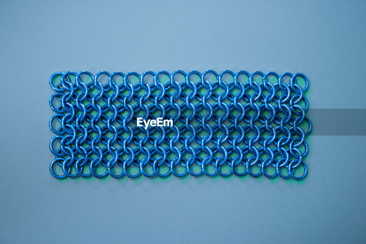 Close-up of chain mail on blue background