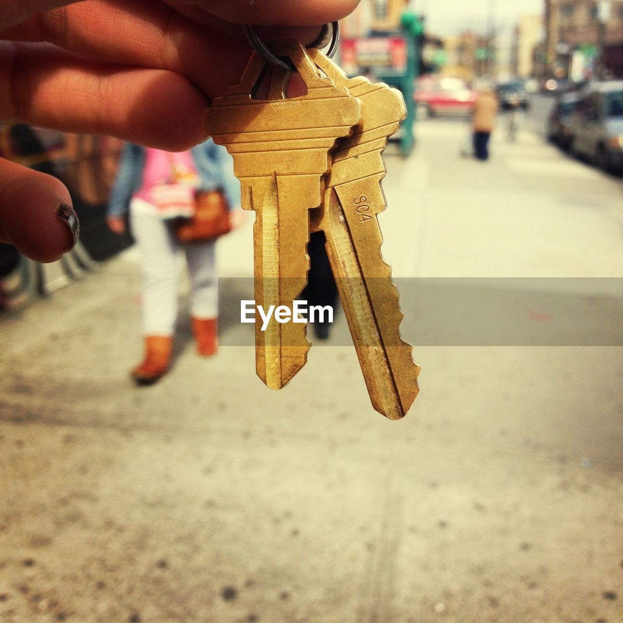 Close-up of cropped hand holding keys on street