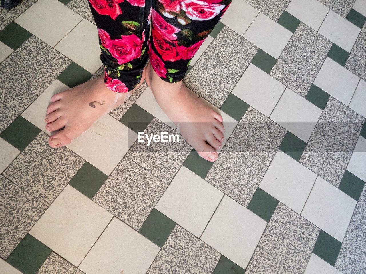 LOW SECTION OF WOMAN STANDING ON FLOOR