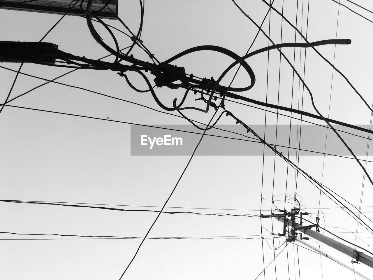 LOW ANGLE VIEW OF POWER LINES AGAINST CLEAR SKY