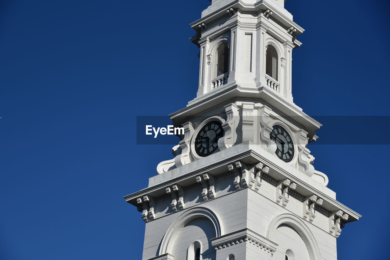 Low angle view of bell tower against blue sky