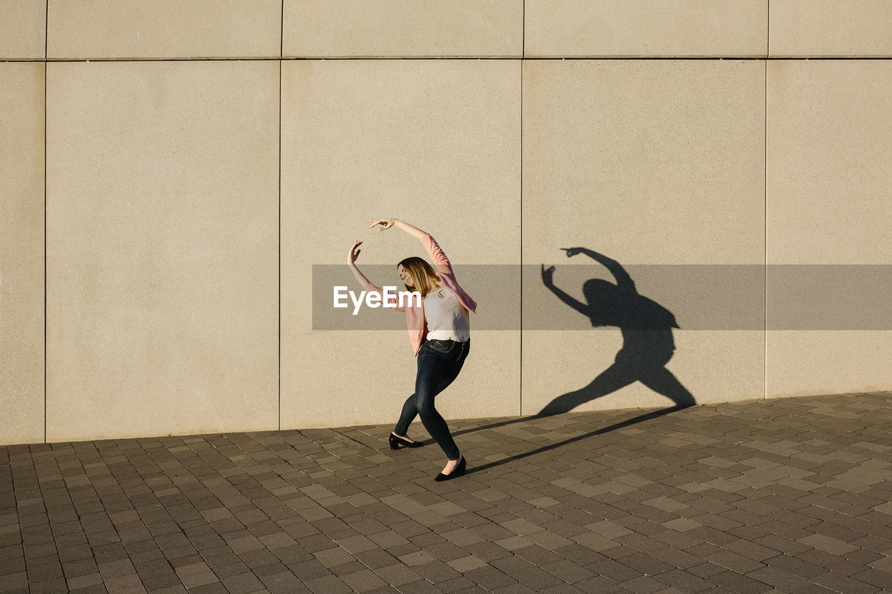 Young woman dancing in city