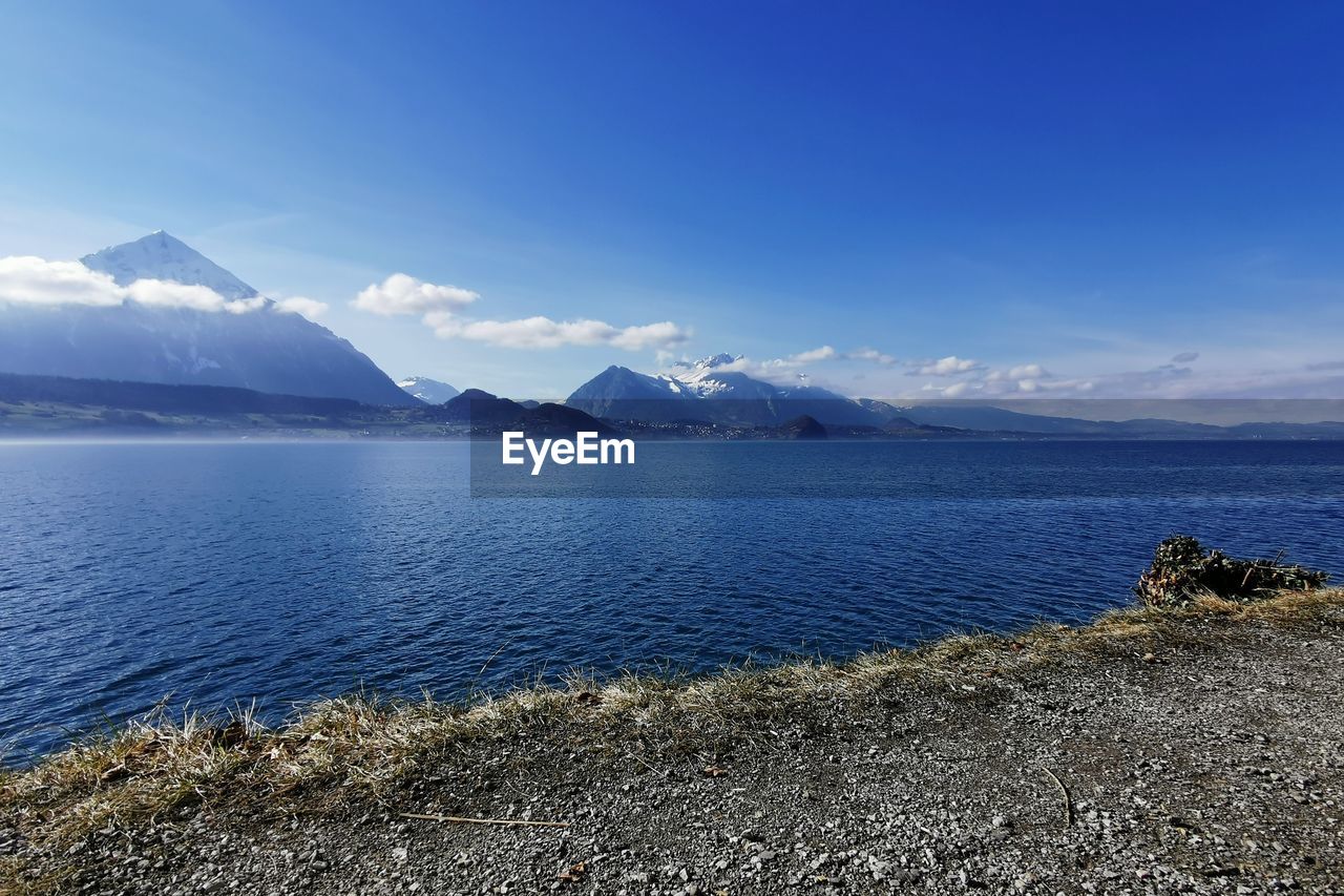 SCENIC VIEW OF SEA BY MOUNTAINS AGAINST SKY