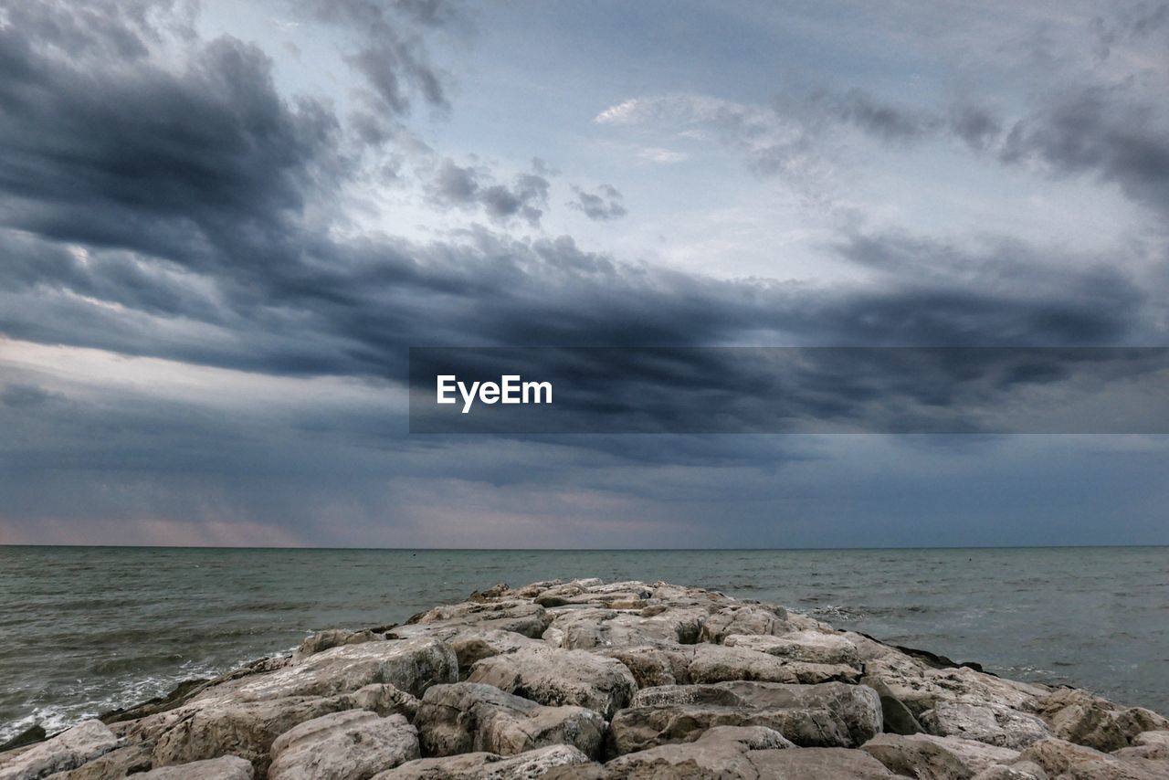 Scenic view of rocks on beach against sky