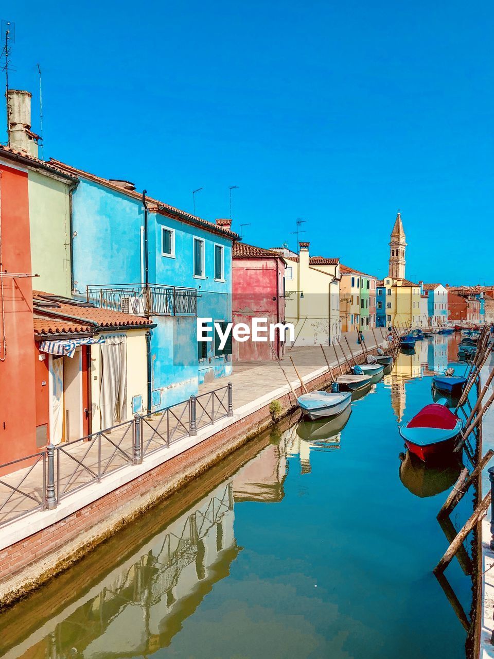 BUILDINGS BY CANAL AGAINST BLUE SKY