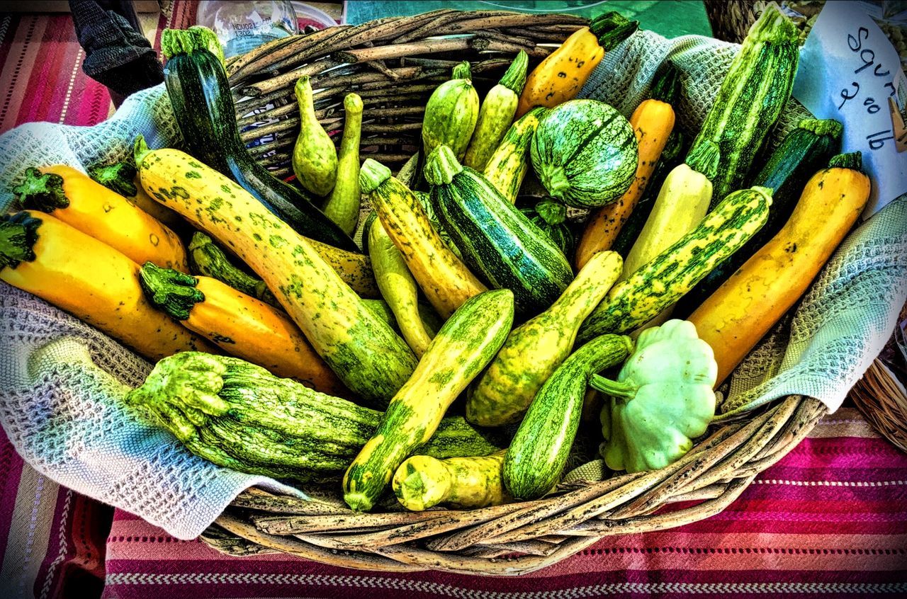 High angle view of squash and zucchini in basket for sale at market stall