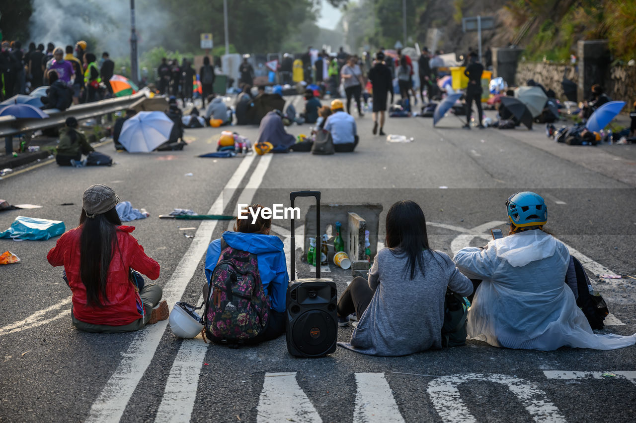 PEOPLE SITTING ON ROAD