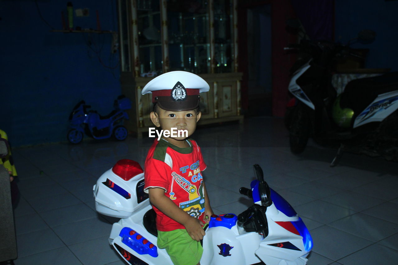 Portrait of cute boy on toy car