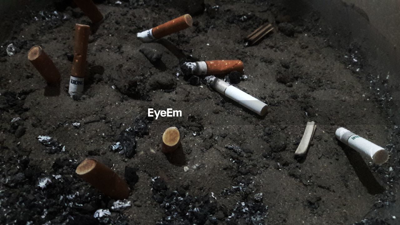 HIGH ANGLE VIEW OF MAN SMOKING CIGARETTE