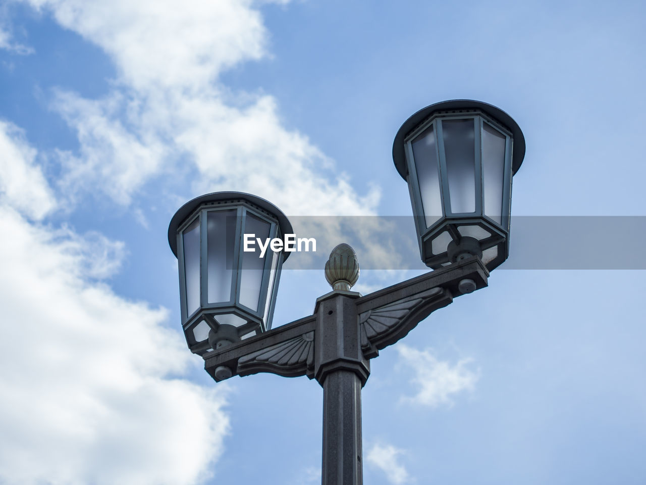 Low angle view of street light at karl marx allee against sky