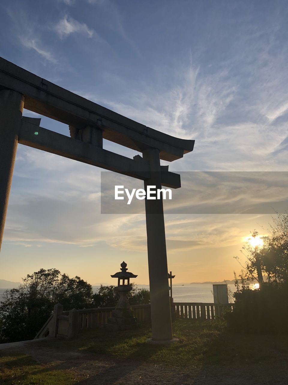 GAZEBO ON FIELD AGAINST SKY AT SUNSET