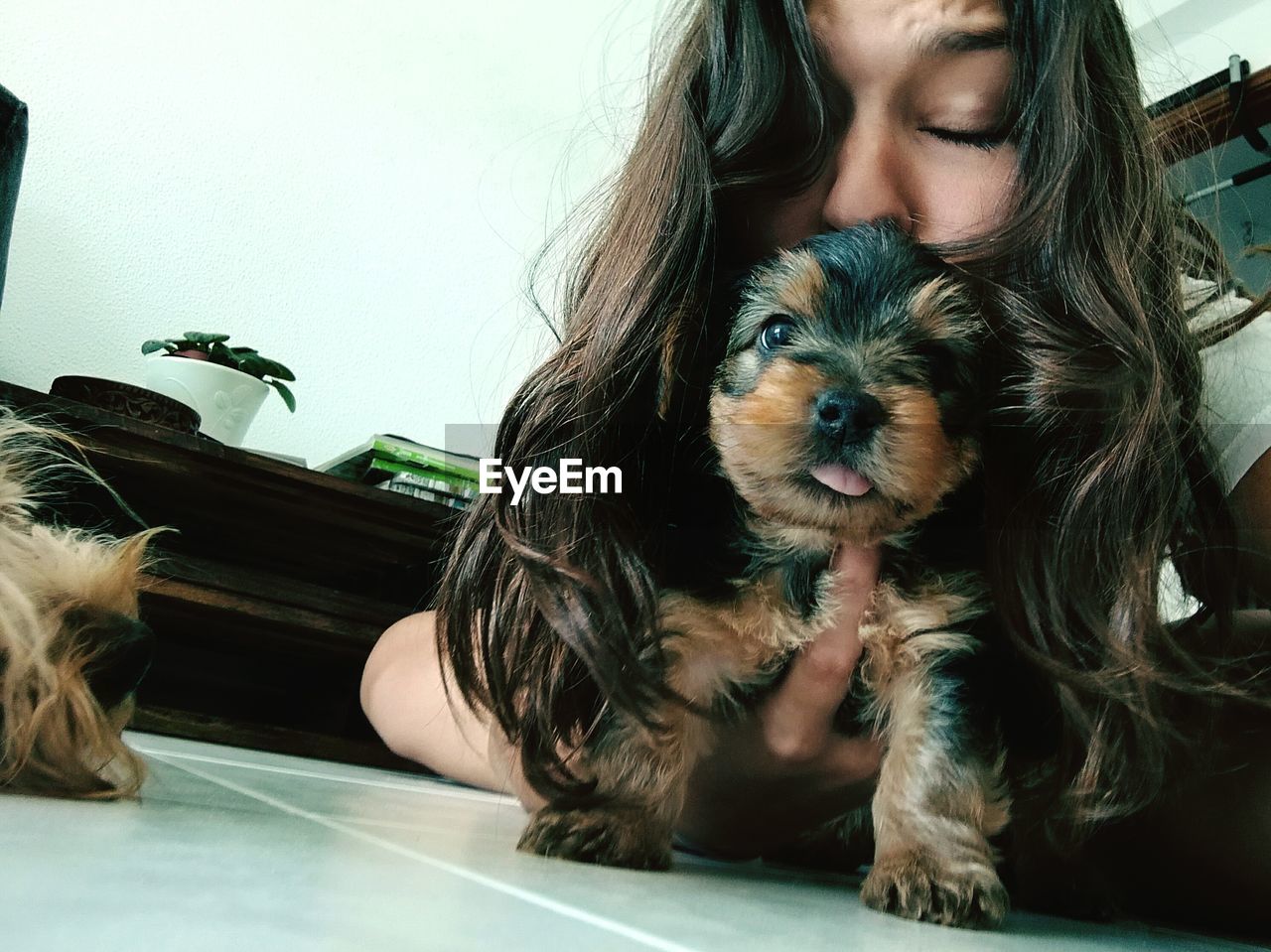 PORTRAIT OF YOUNG WOMAN WITH DOG AT HOME