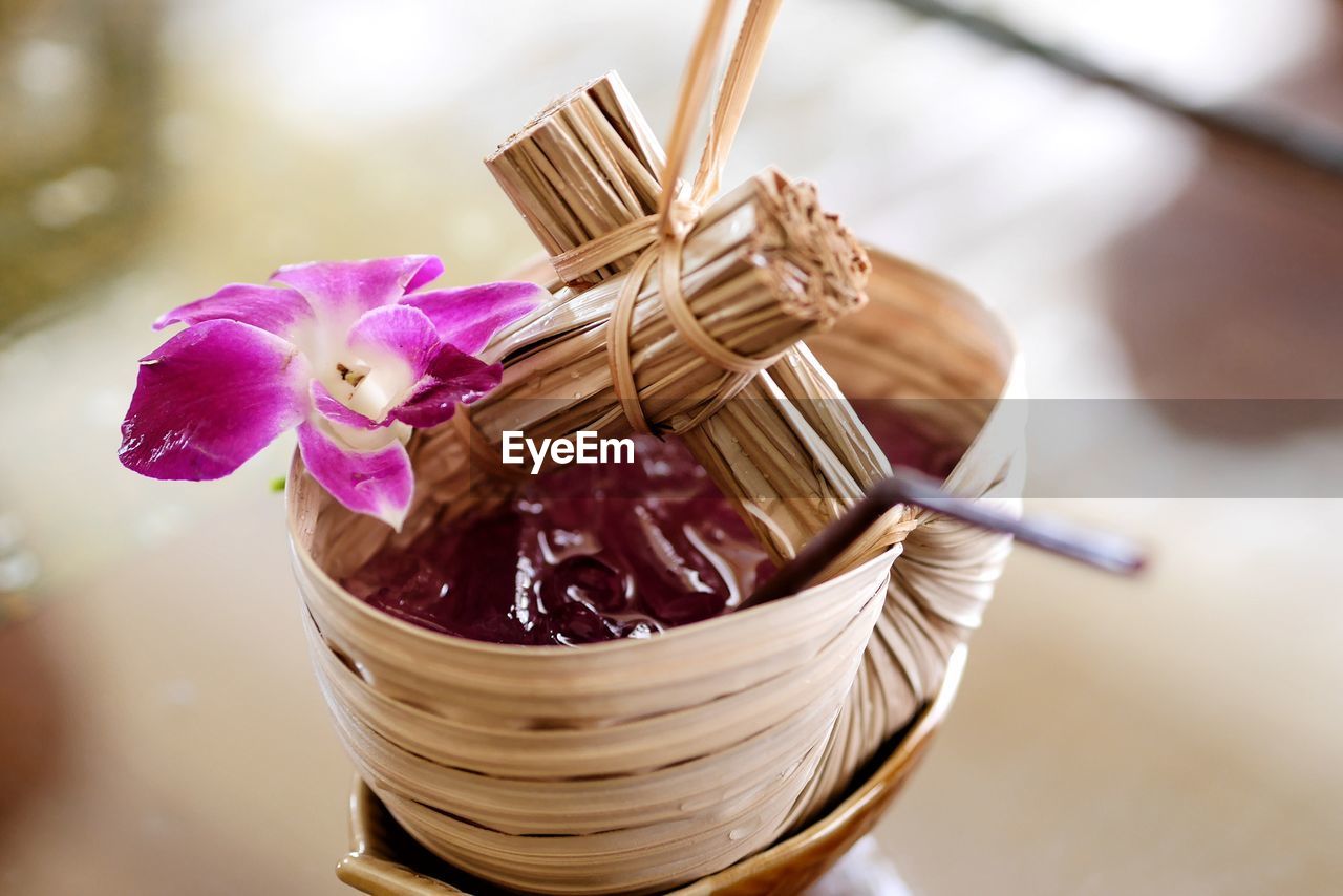 CLOSE-UP OF PINK BASKET WITH FLOWERS AND WICKER