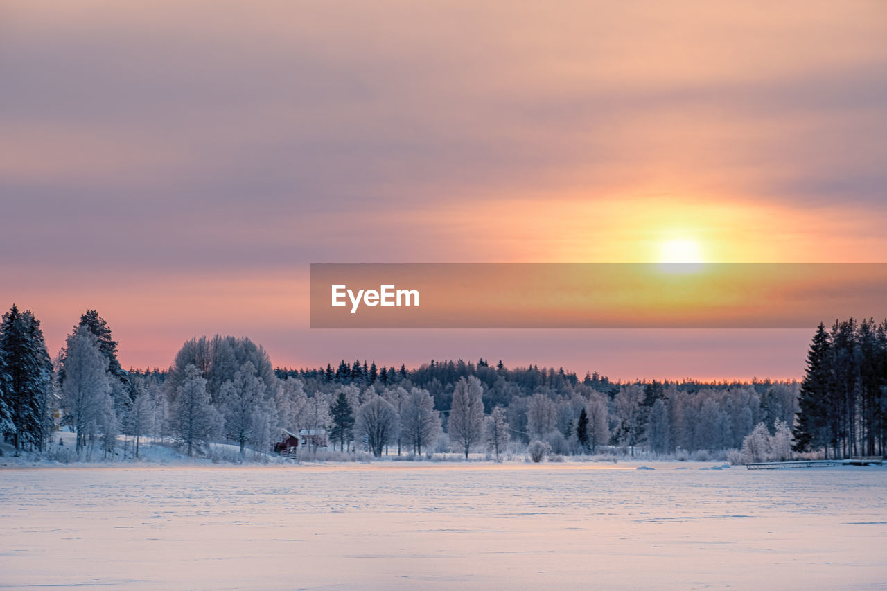 Scenic view of snow covered landscape against sky during sunset