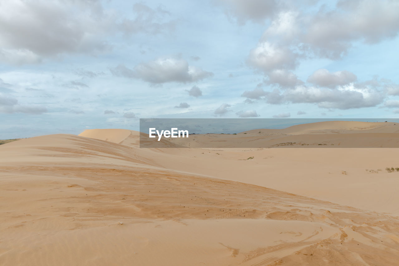 Sand dunes in desert against sky