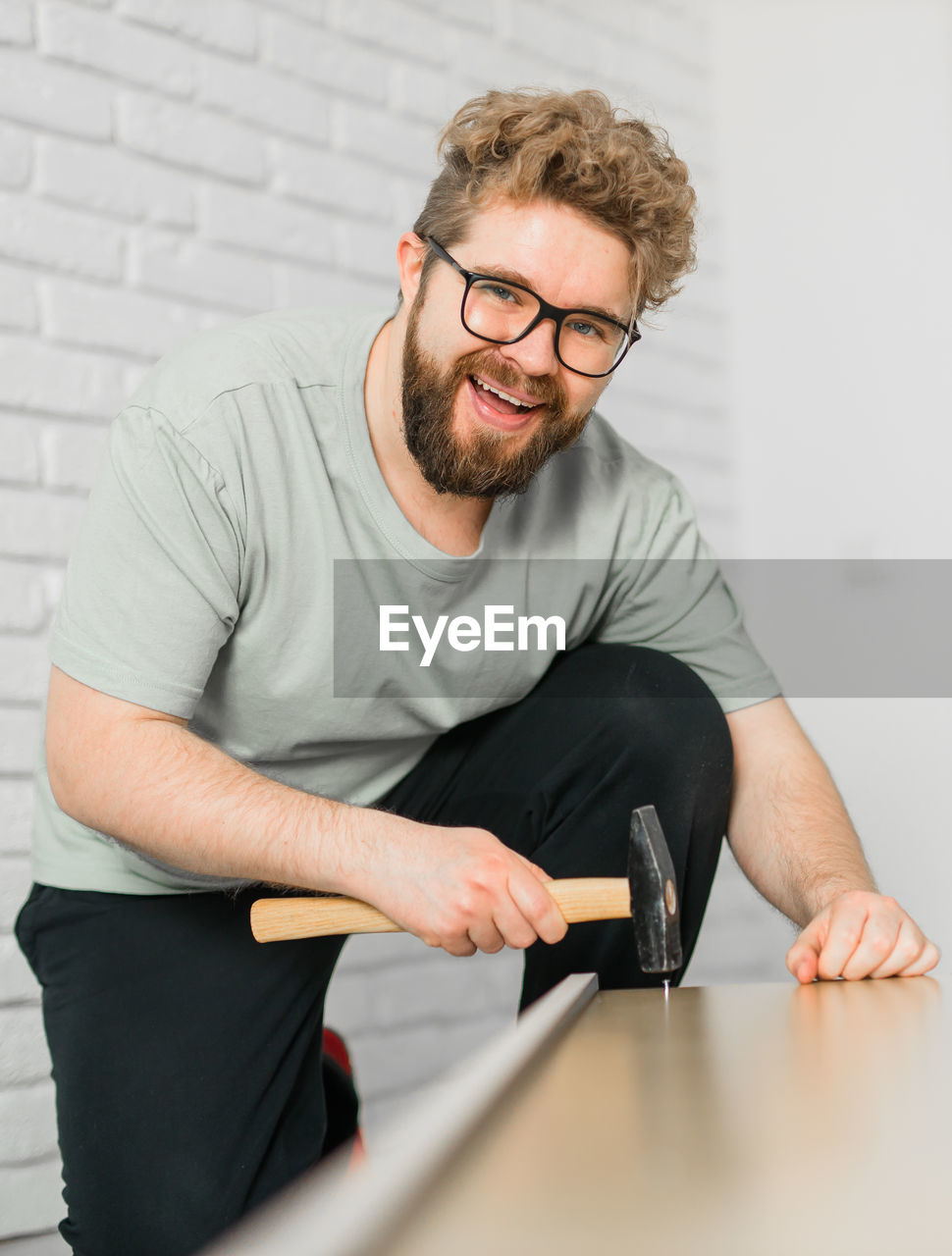 portrait of serious man using mobile phone while sitting on table