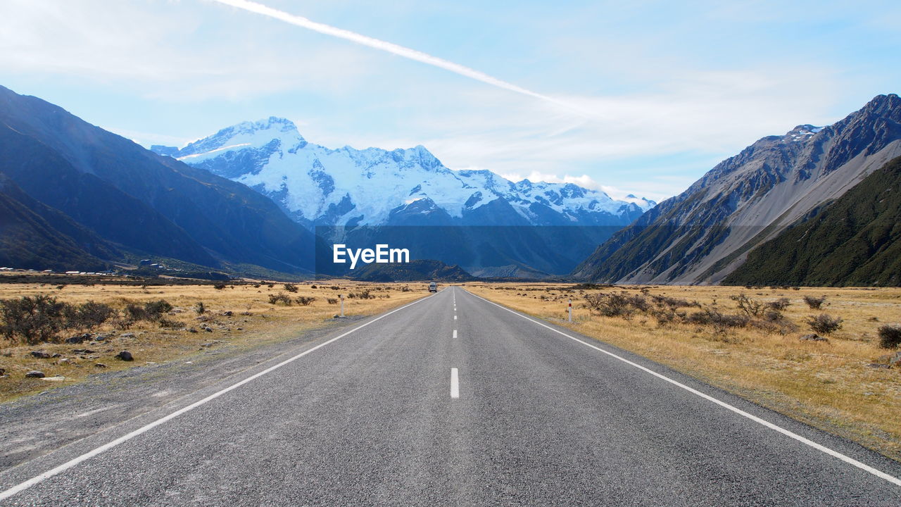 ROAD BY MOUNTAINS AGAINST SKY