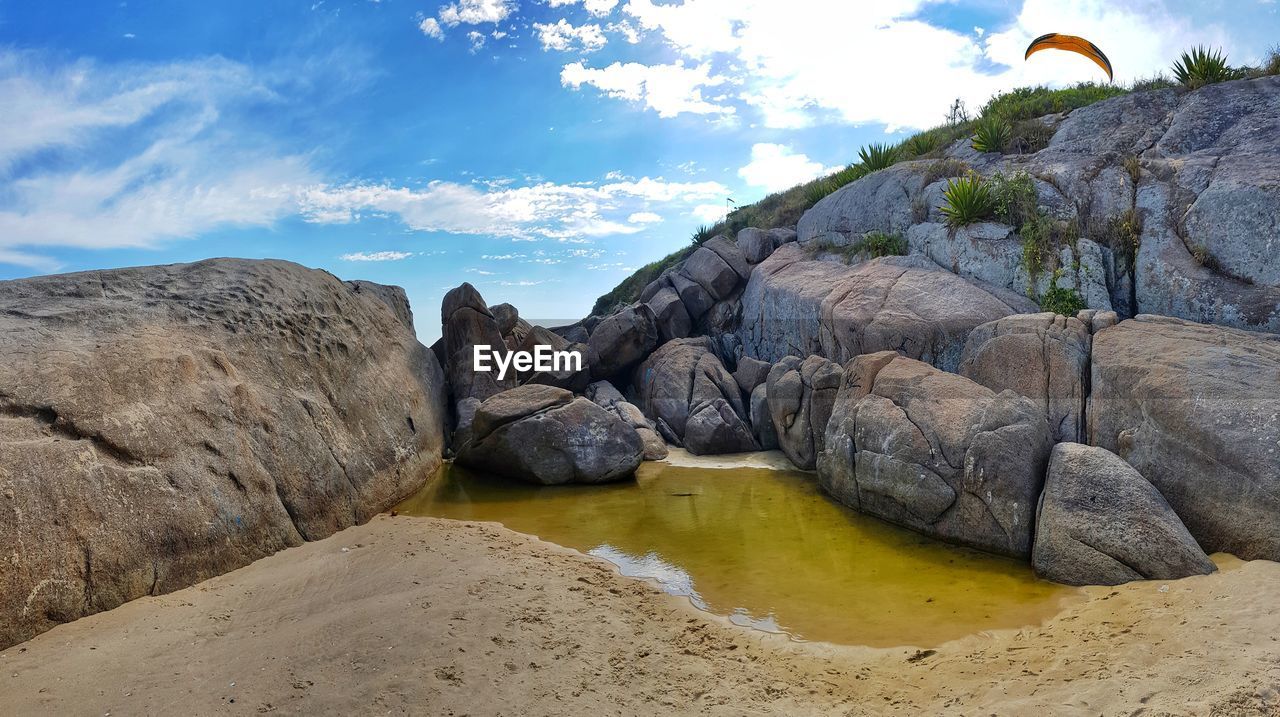 Rocks on beach against sky