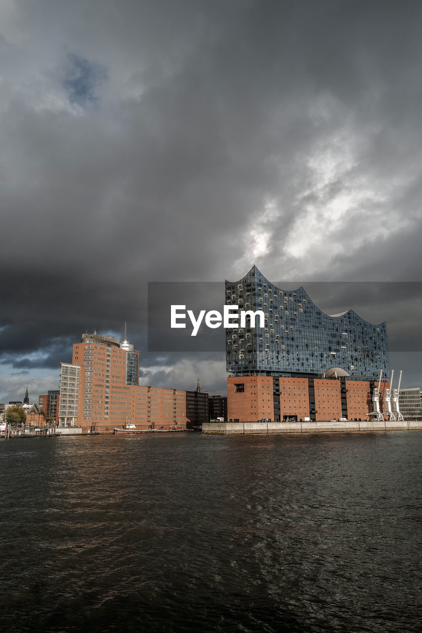 Buildings in city against cloudy sky