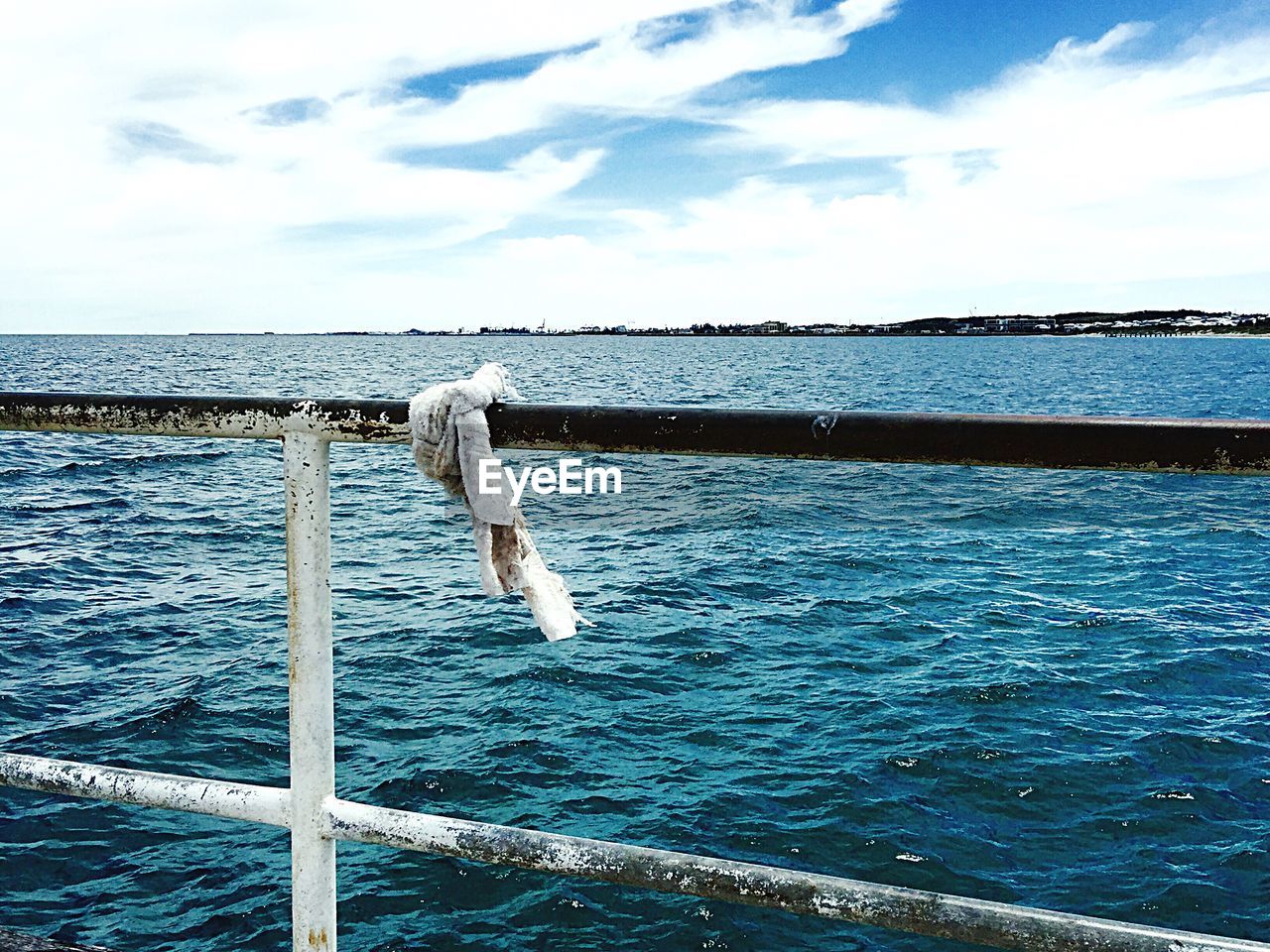 Close-up of railings against calm blue sea