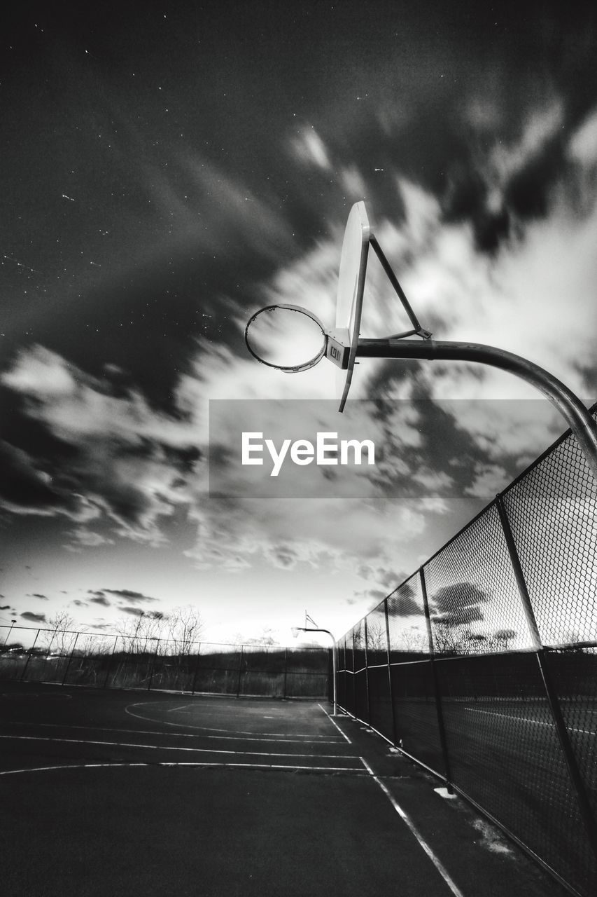 Low angle view of basketball hoop against cloudy sky