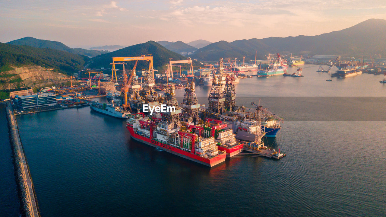 BOATS IN SEA AGAINST MOUNTAINS