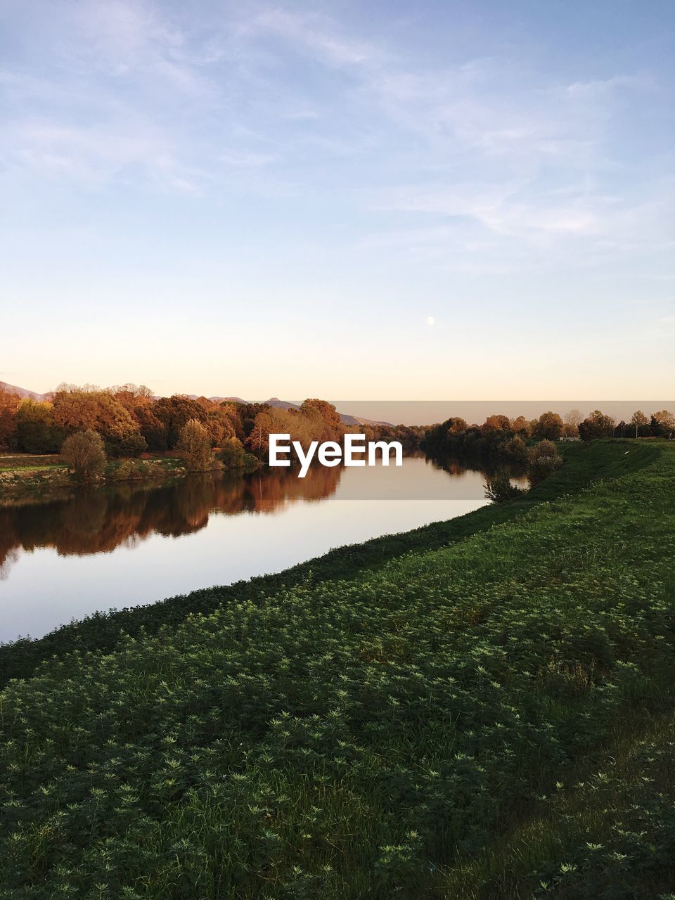 Scenic view of lake against sky at sunset