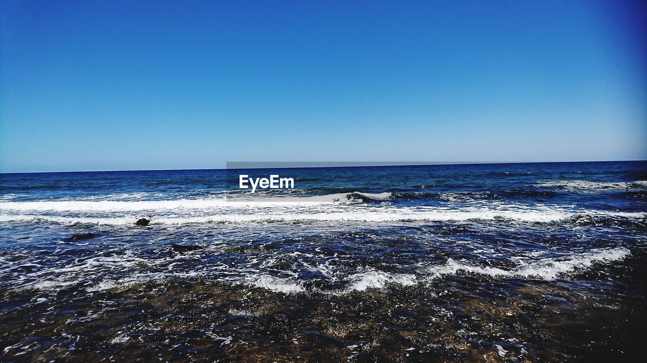 Scenic view of sea against clear blue sky