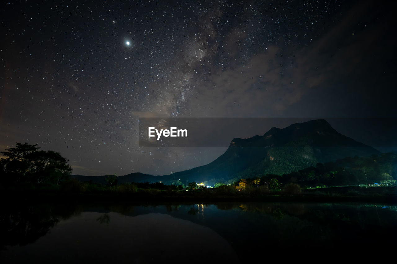 SCENIC VIEW OF LAKE AGAINST MOUNTAIN RANGE AT NIGHT