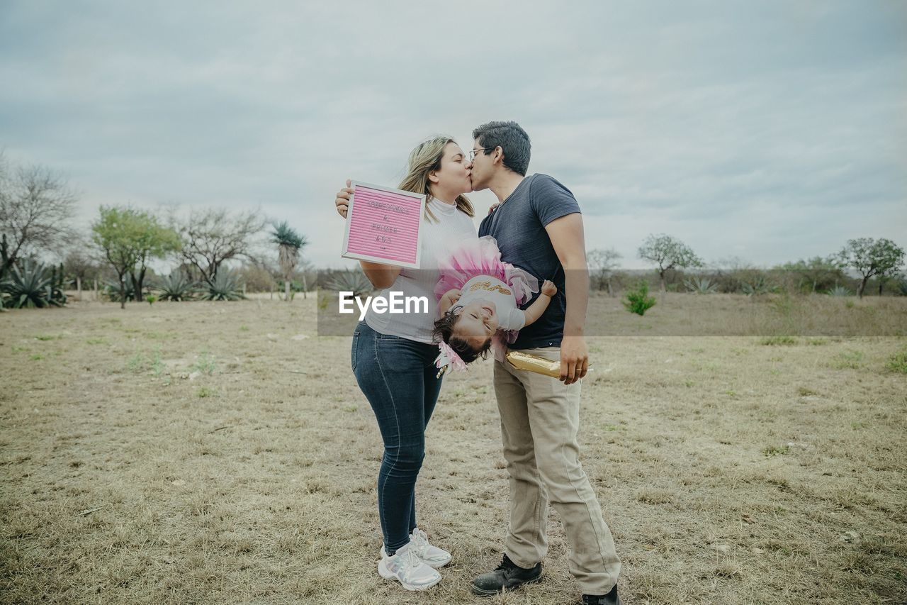 Full length of couple kissing while standing outdoors