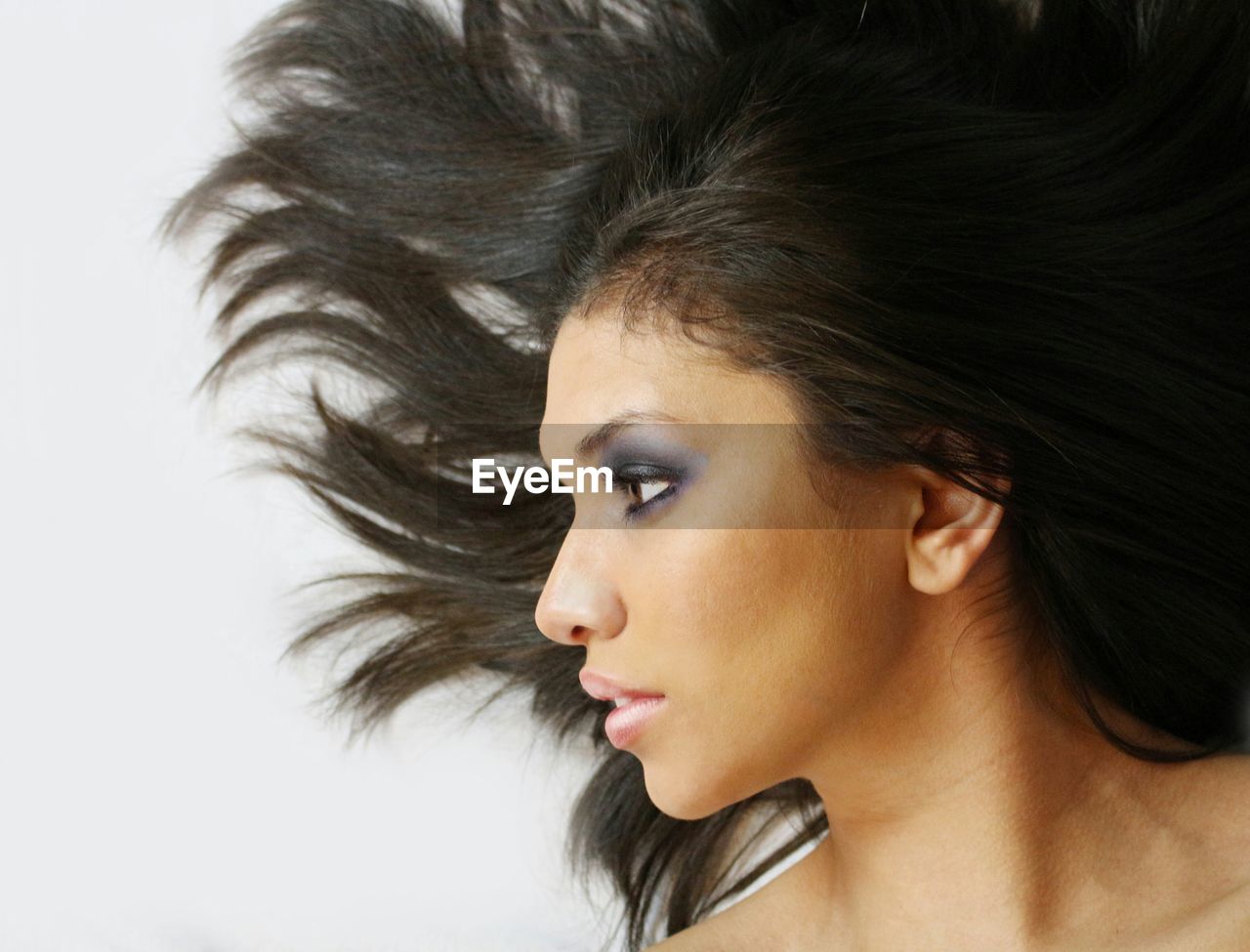 Beautiful woman with tousled hair against white background