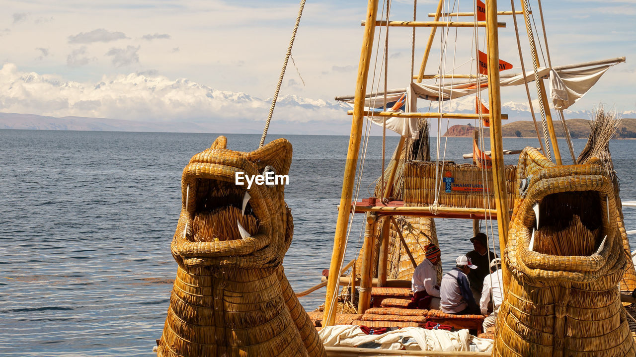 MAN STANDING AT SEA AGAINST SKY