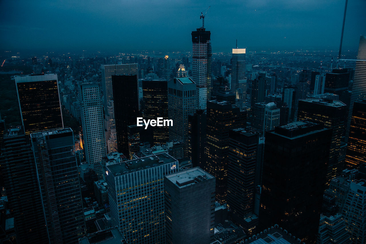 Aerial view of illuminated buildings in city at dusk