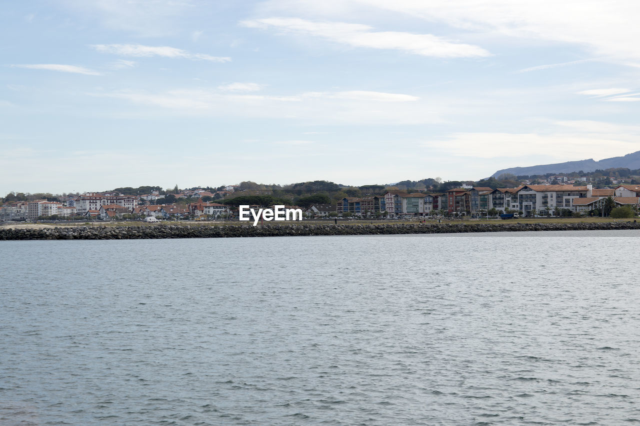 View of town by sea against sky