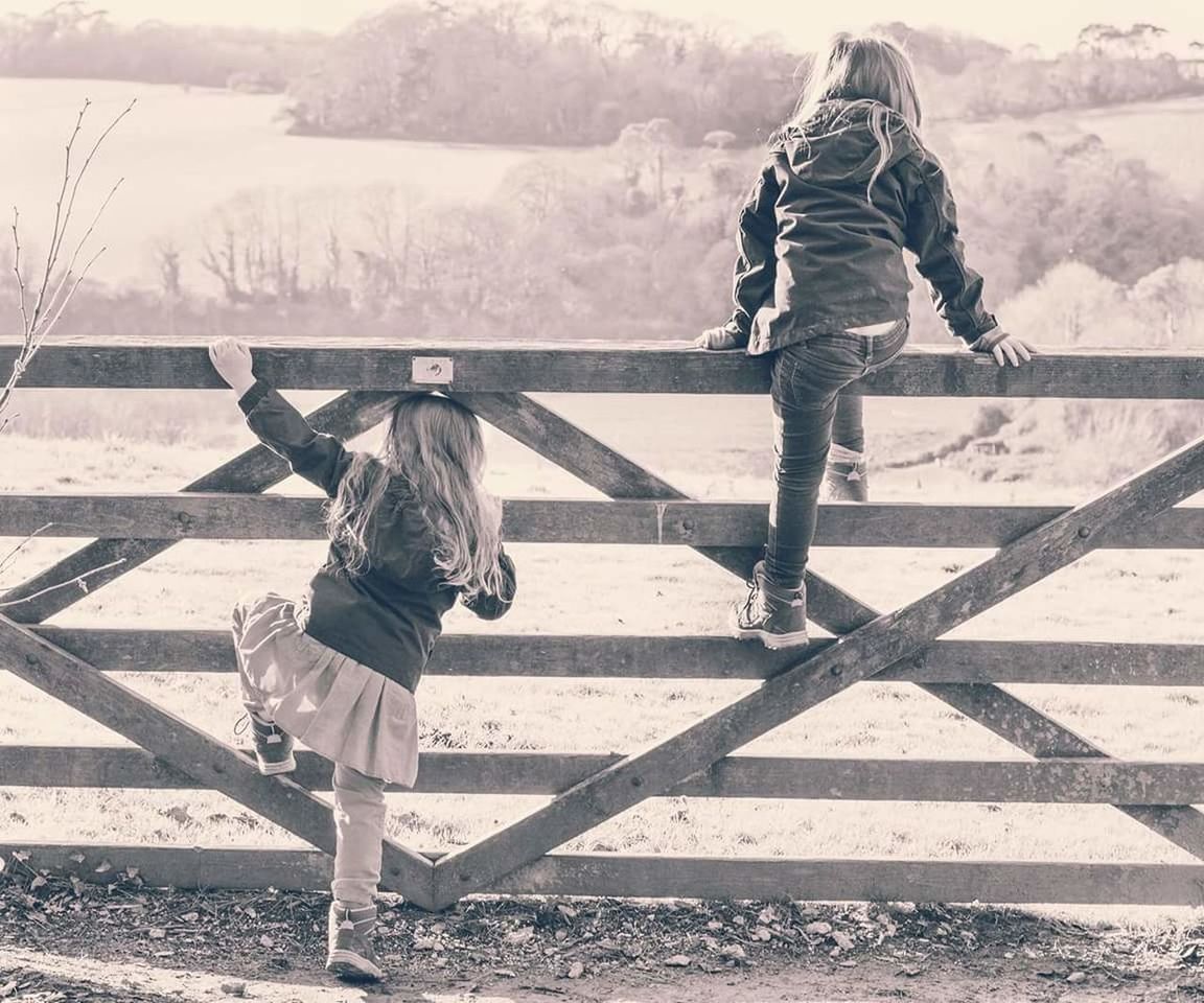 Girls climbing on fence