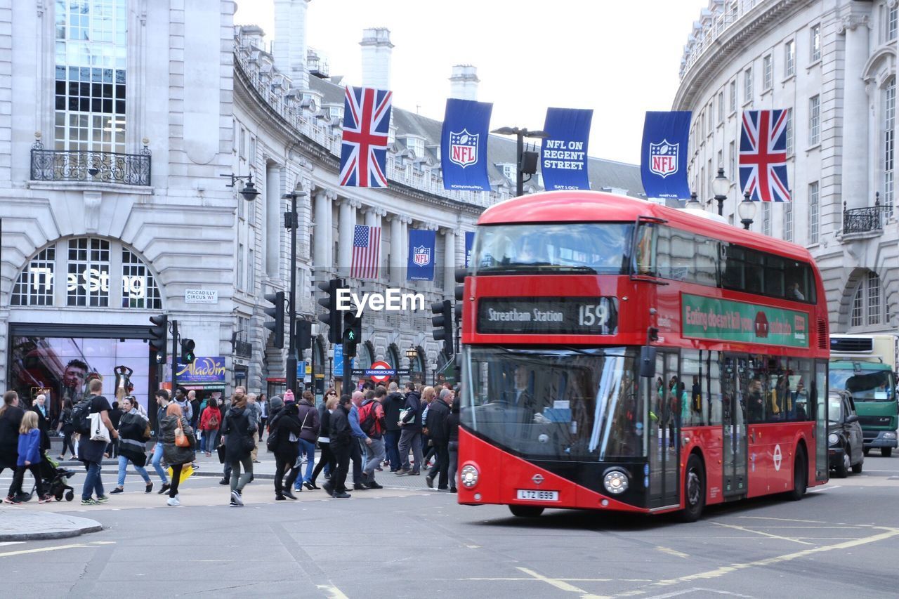 PEOPLE STANDING IN FRONT OF BUS