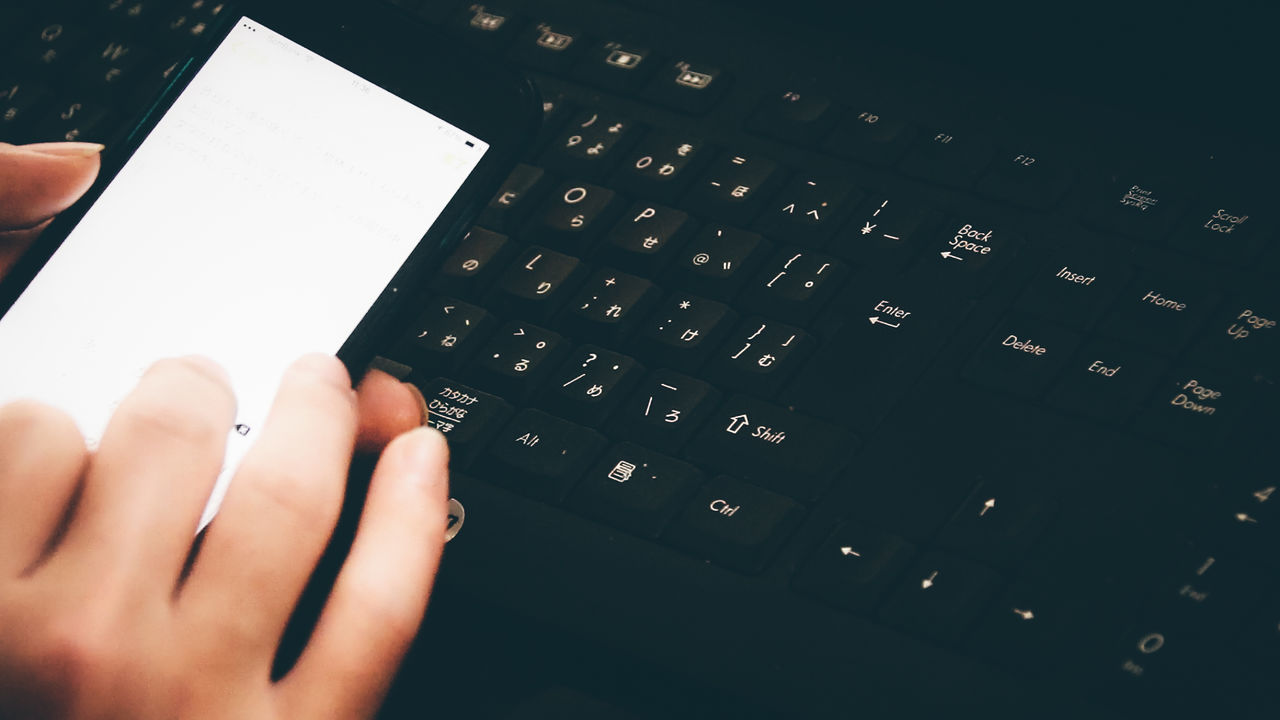 CLOSE-UP OF PERSON USING LAPTOP